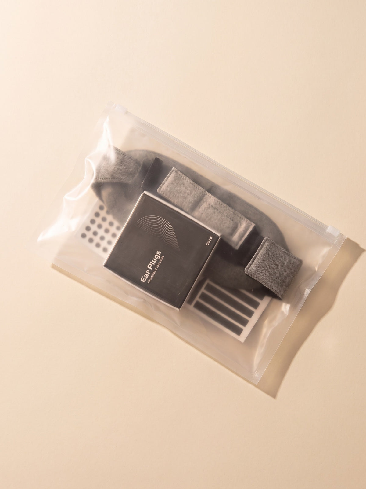 DAYBLIND Day Sleep Kit packed in its zip pouch — blackout mask, earplugs and LED stickers, on cream