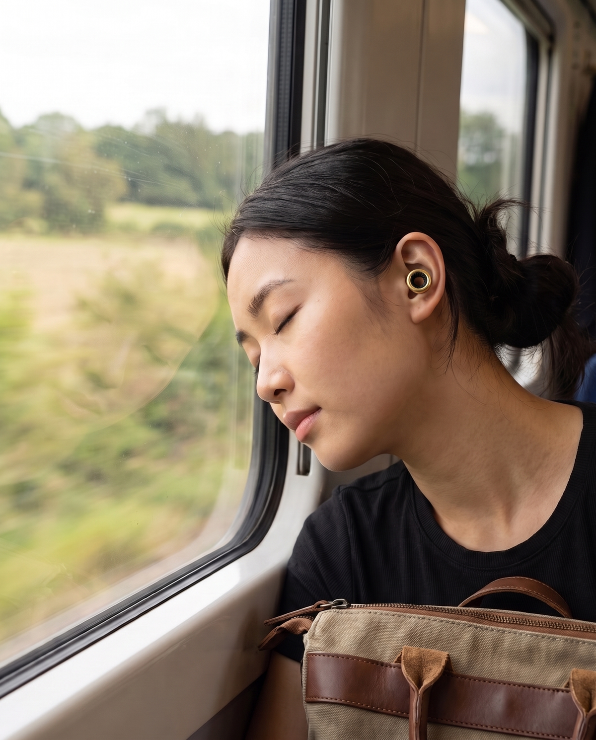 Traveller resting on a train wearing Ring earplugs