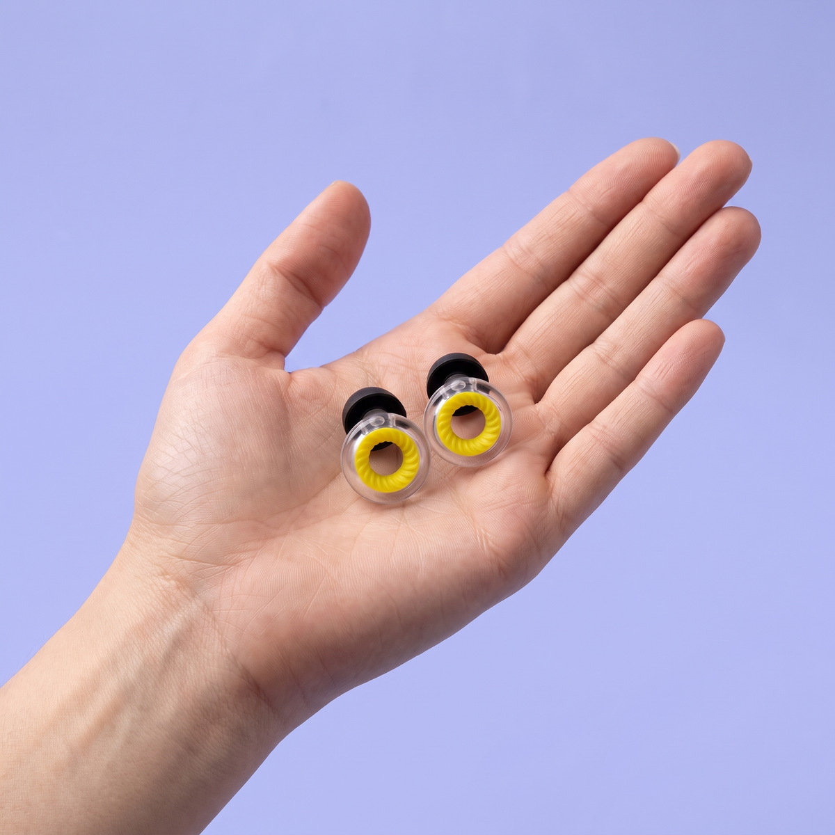 Ring Earplugs in Clear Yellow, in hand