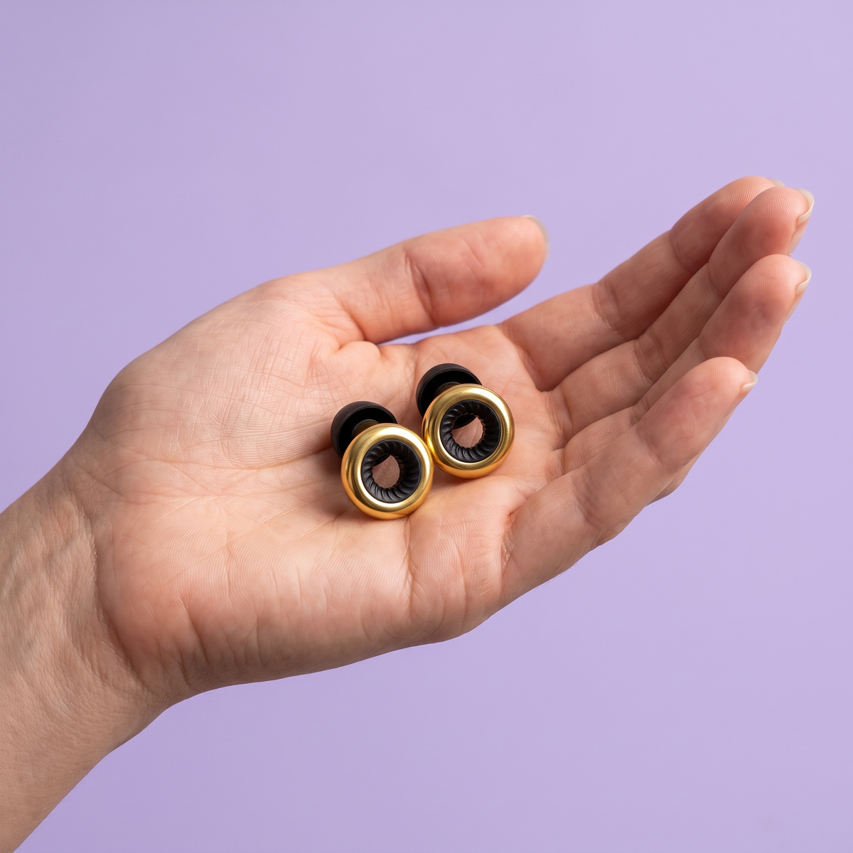 Ring Earplugs in Gold Black, in hand